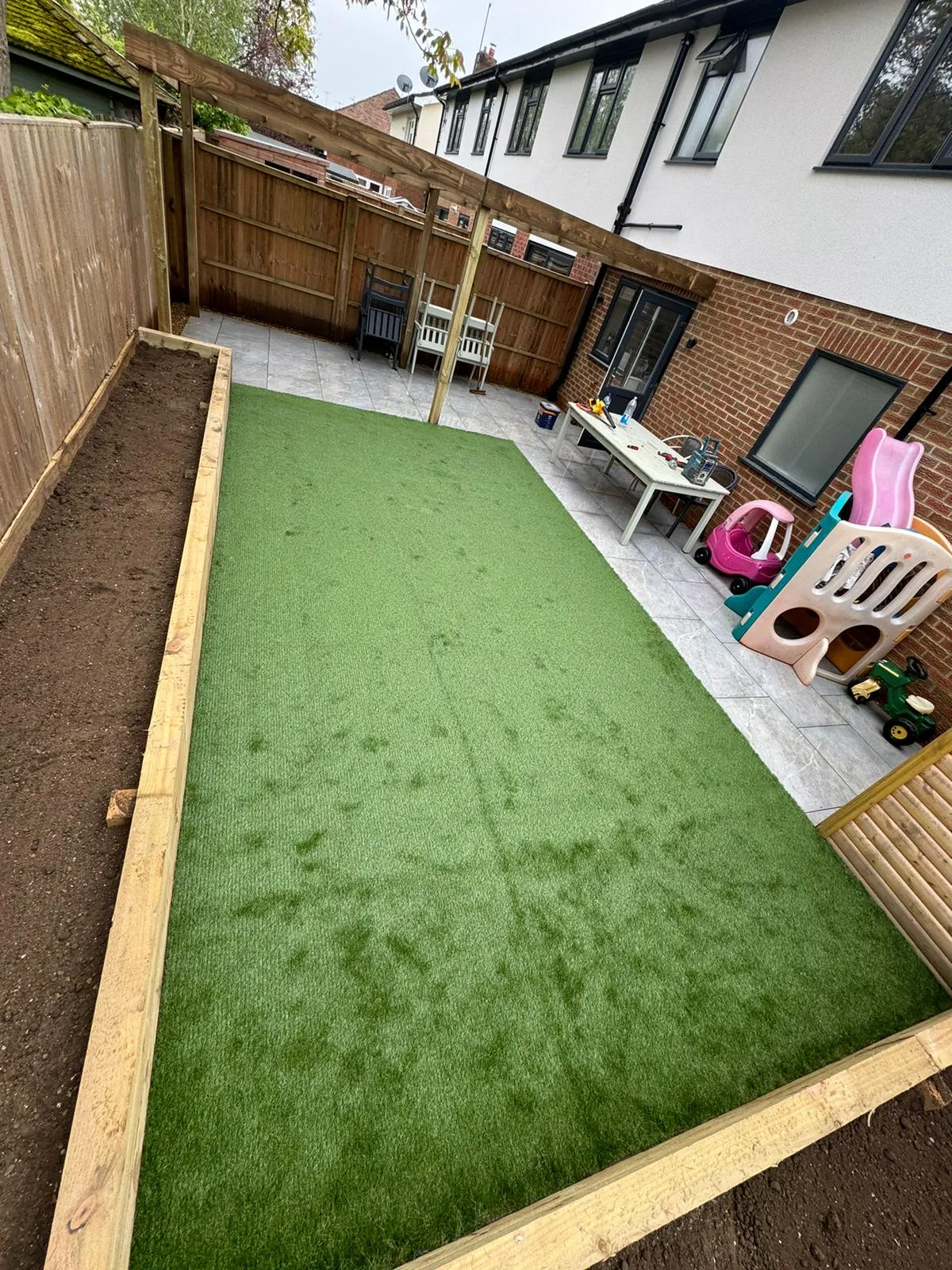 A backyard with a green lawn and a wooden fence.